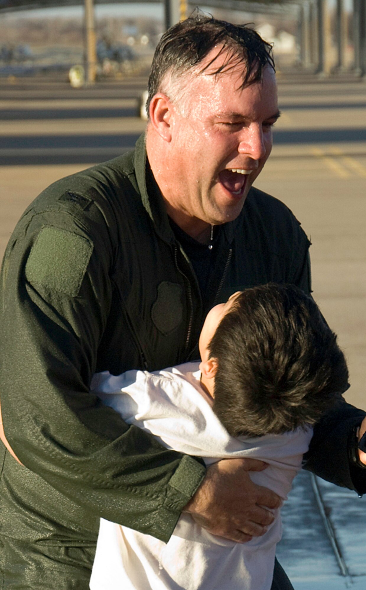 Col. Richard Murphy receives a hug from his son, Matthew, after getting the traditional "hosing down" upon returning from his final aircraft flight at Vance, Jan. 22. (U.S. Air Force photo/ Terry Wasson)