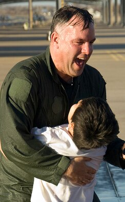 Col. Richard Murphy receives a hug from his son, Matthew, after getting the traditional "hosing down" upon returning from his final aircraft flight at Vance, Jan. 22. (U.S. Air Force photo/ Terry Wasson)