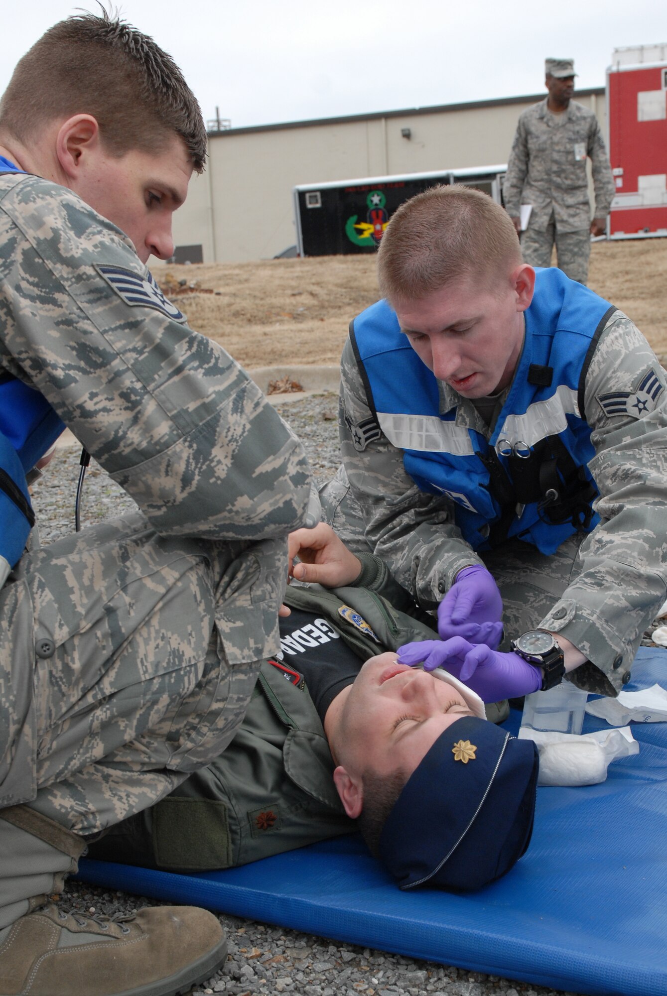 Staff Sgt. Christopher Gilbert and Senior Airmen Dennis Breyfogle, 19th Medical Group, apply bandages to simulated injuries to a patient's face, after a simulated explosion during a major accident response exercise Jan. 22. The MARE lasted approximately five hours and provided base Airmen the opportunity to train for real world situations. (U.S. Air Force photo by Senior Airman Christine Clark)