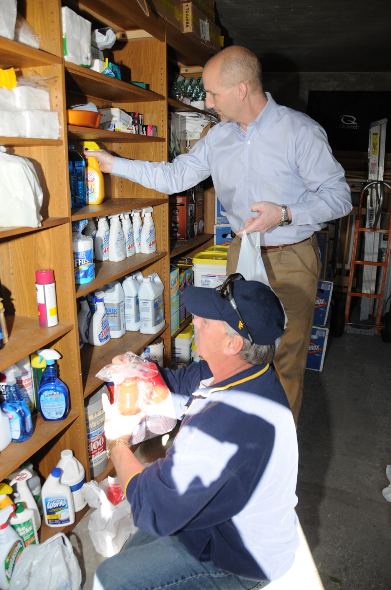 Brent Hinton, standing, general manager of the Wal-Mart distribution center in Brookhaven, Miss., and Larry Vetter, Keesler Fisher House director, stock shelves with cleaning supplies, nonperishable food items and other items in  Fisher House’s storage building.  Wal-Mart also donated $250 to the facility, a home away from home for families of patients undergoing treatment at Keesler Medical Center and the Biloxi Veterans Affairs Medical Center.  (U.S. Air Force photo by Kemberly Groue)