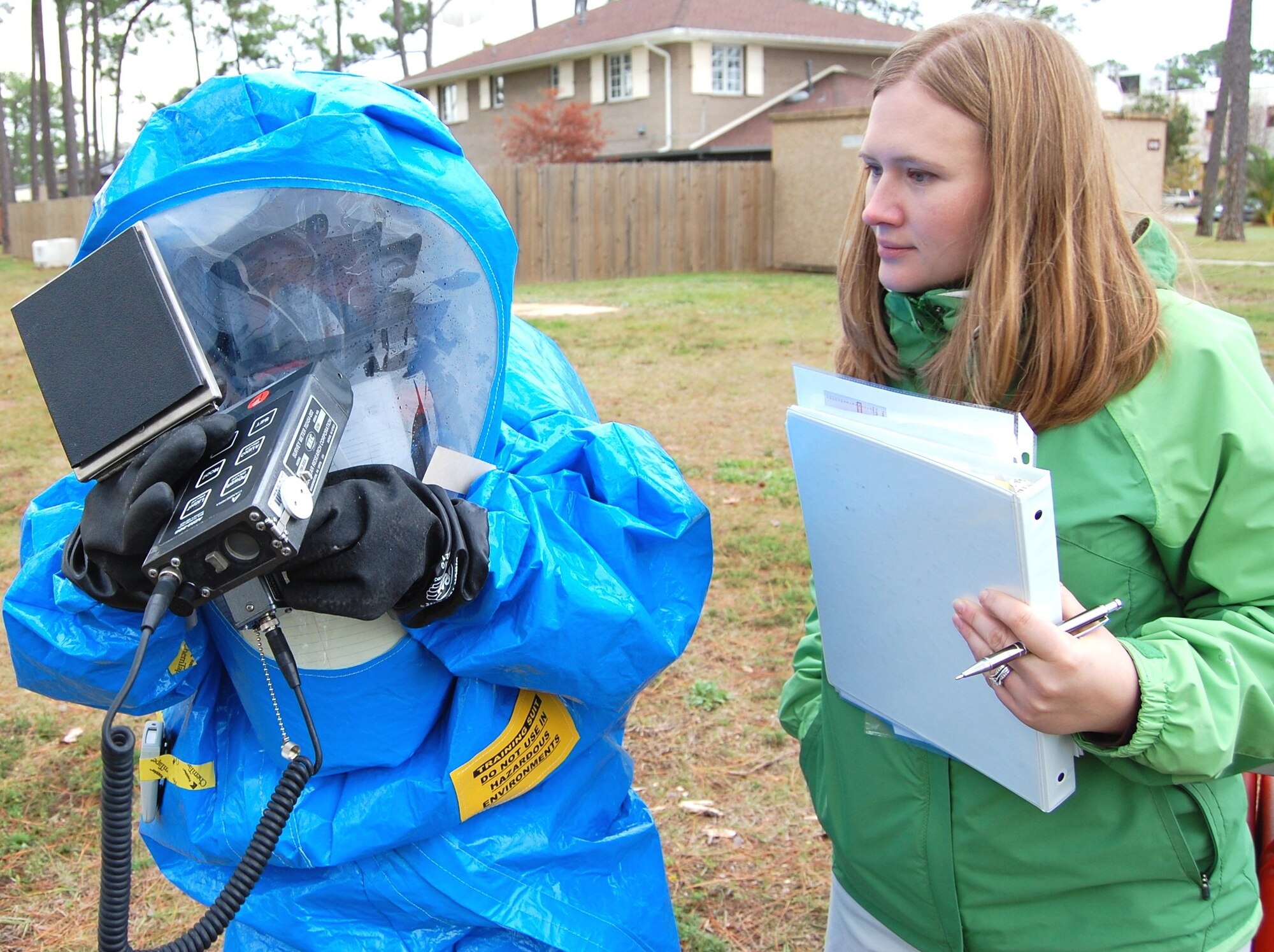 Staff Sgt. Billy Wince, left, an 81st AMDS bioenvironmental health flight technician, is monitored by Alliance Solutions analyst Jessica Feil as he takes readings with a radiation detector at a simulated accident site.  The “accident” involved a spill of radioactive and chemical materials and was one of the realistic scenarios used during the CBRN Challenge.  (U.S. Air Force photo by Steve Pivnick)