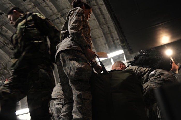 Air Force members unload luggage after cargo was delivered in Port-au-Prince, Haiti, Jan. 22, 2010. The Airmen delivered a large shipment of money from Charleston AFB for the U.S. Embassy in Port-au-Prince after the collapse of two major banks in Haiti used by the embassy. (U.S. Air Force photo/Senior Airman Katie Gieratz)(RELEASED)
