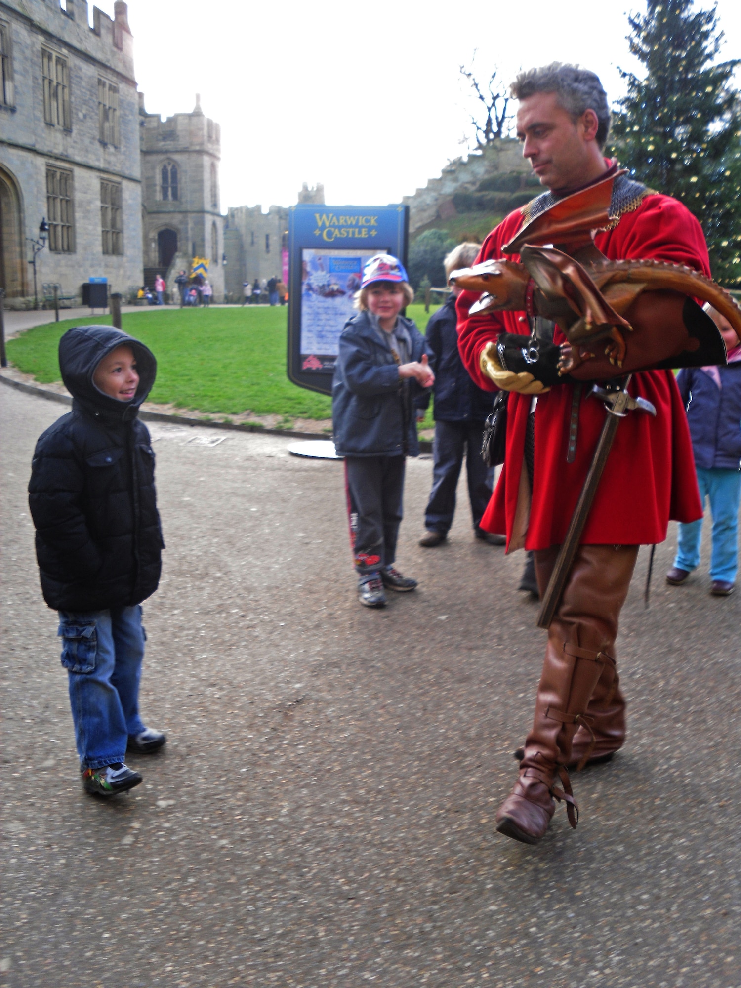 Tristan Estes, age 5, is entertained by a court jester with a dragon puppet.  The central courtyard was unique and had several events throughout the day to get children involved.
Once inside the grounds, you are free to explore the castle.  There is a large playground for children and a princess tower.  The princess tower offers story times with actors in period costume.  (U.S. Air Force photo by Staff Sgt. Connor Estes)
