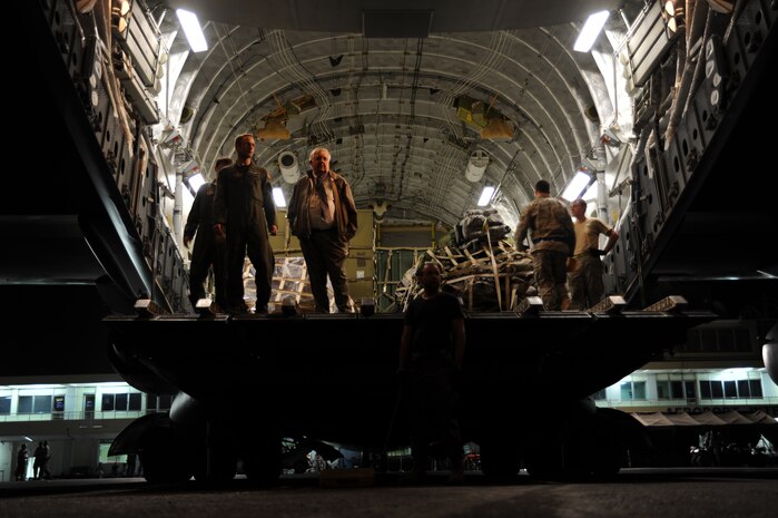 Air Force members and Richard Ivy, right, wait to unload a shipment of U.S. currency from a Travis AFB C-17 at Port-au-Prince, Haiti, Jan. 22. The important package was a large sum of money scheduled for delivery to the U.S. Embassy in Port-au-Prince. Mr. Ivy is a U.S. State Department disbursing officer. (U.S. Air Force photo/Senior Airman Katie Gieratz)(RELEASED)