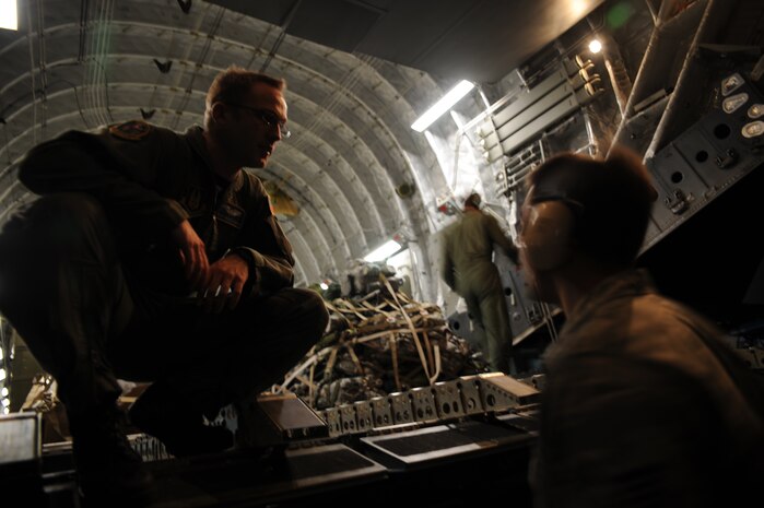 Staff Sgt. Chuck O'Guinn speaks with Staff Sgt. Caleb Carmody about unloading cargo while at Port-au-Prince, Haiti, Jan. 22, 2010. The aircraft took off from Charleston AFB carrying a special shipment of money for the U.S. Embassy in Haiti along with members of security forces and intelligence squadrons in support of Operation Unified Response. Sergeant O'Guinn is a loadmaster with the 728th Airlift Squadron at McChord AFB, Wash., and Sergeant Carmody is an air transportation journeyman from McGuire AFB, N.J. (U.S. Air Force photo/Senior Airman Katie Gieratz)(RELEASED)