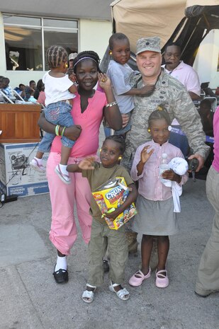Lt. Col. Randon Draper, 18th Air Force Legal Office, spends a few moments wtih the first five Haitian children that he helped send to their adoptive parents after the devastaging 7.0 earthquake there Jan. 12.  He's been on the ground at Port-au-Prince since Jan. 14 and has helped immigration and state department officials expedite valid adoptions for several hundred children. (courtesy photo)