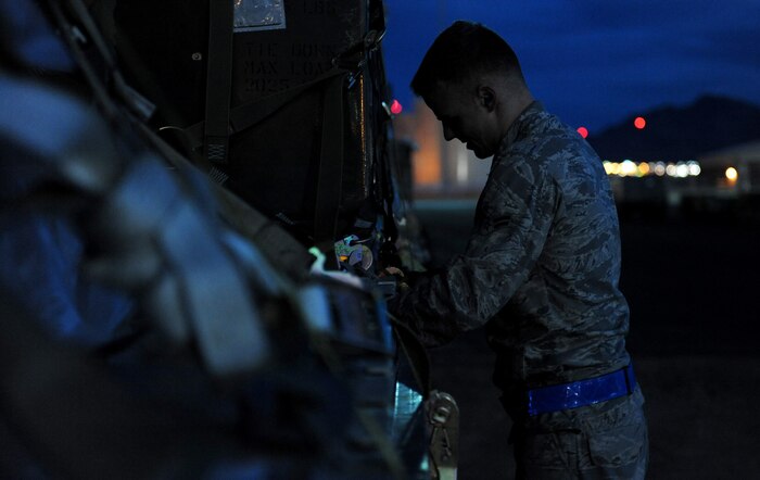 NELLIS AIR FORCE BASE, Nev. -- Airman 1st Class William Anderson, a vehicle operator with the 99th Logistics Readiness Squadron, straps down a pallet of cargo while working at the Cargo Deployment Function (CDF) during the 99th Air Base Wing Operational Readiness Inspection, Jan. 25.   (U.S. Air Force photo by Staff Sgt. Taylor Worley)