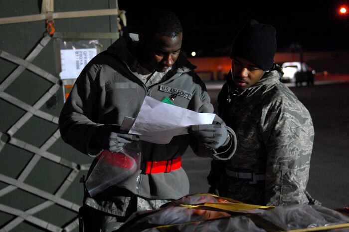 NELLIS AIR FORCE BASE, Nev. -- Staff Sgt. Benjamin Harrison and Airman 1st Class Isaac Hooper, cargo deployment function augmentees from the 99th Logistics Readiness Squadron, check the documentation of a pallet being processed for deployment during the 99th Air Base Wing Operational Readiness Inspection, Jan. 25. (U.S. Air Force photo by Staff Sgt. Taylor Worley)