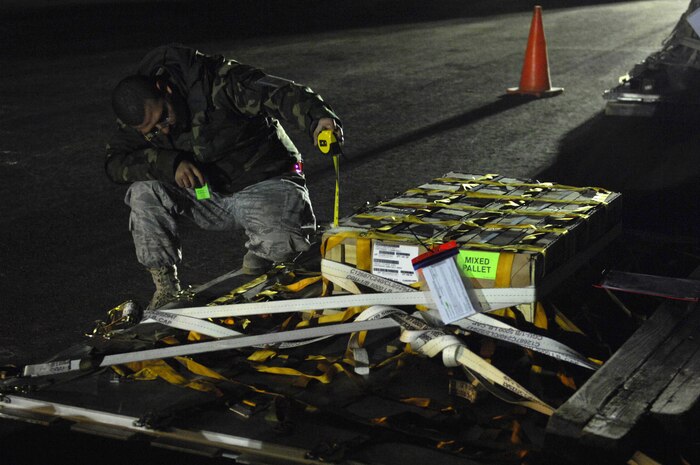 NELLIS AIR FORCE BASE, Nev. -- Senior Airman Armando Encinias, an air transportation journeyman assigned to the 99th Logistics Readiness Squadron, measures the height of a pallet during the 99th Air Base Wing Operational Readiness Inspection, Jan. 25. (U.S. Air Force photo by Staff Sgt. Taylor Worley)