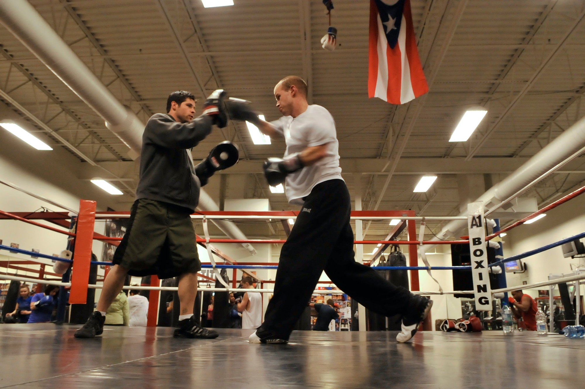 AURORA, Colo. -- Staff Sgt. Joshua Hinton, Air Reserve Personnel Center Directorate of Communications and Information knowledge operations manager, right, trains in the ring with professional boxer and A1 Boxing trainer Terry Bergl Oct. 21. Boxing fitness programs are full body workouts that can burn 800 to 1,000 calories for every one hour session. (U.S. Air Force photo by Senior Airman Kathrine McDowell)