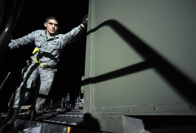 NELLIS AIR FORCE BASE, Nev. -- Airman 1st Class Kaleb Salaza, 99th Logistics Readiness Squadron, pushes cargo off of a Tunner 60K Aircraft Cargo Loader and onto a deck during the 99th Air Base Wing Operational Readiness Inspection, Jan. 25. (U.S. Air Force photo by Tech. Sgt. Michael R. Holzworth)