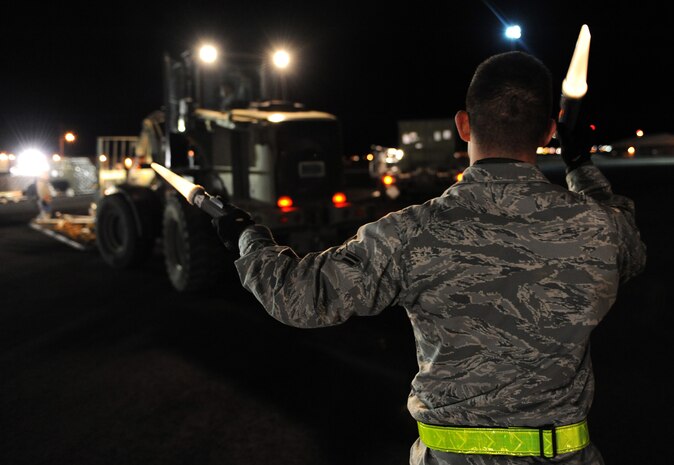 NELLIS AIR FORCE BASE, Nev. -- Airman 1st Class Kaleb Salaza, 99th Logistics Readiness Squadron, marshals cargo on the flight line during the 99th Air Base Wing Operation Readiness Inspection Jan. 25. (U.S. Air Force photo by Tech. Sgt. Michael R. Holzworth)