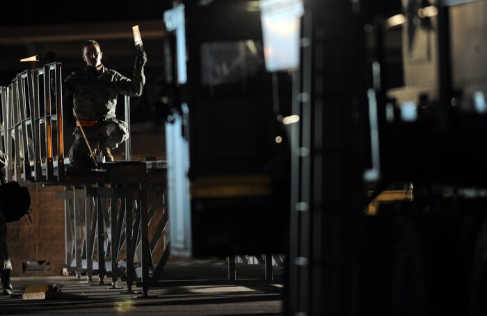 NELLIS AIR FORCE BASE, Nev. -- Airman 1st Class Anthony Shewmake, 99th Logistics Readiness Squadron, directs a Tunner 60K Aircraft Cargo Loader towards a cargo deck on the flight line during the Operational Readiness Inspection, Jan. 25. (U.S. Air Force photo by Tech. Sgt. Michael R. Holzworth)