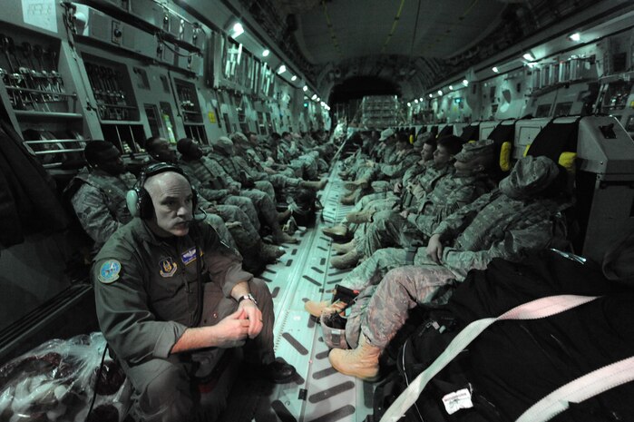 Master Sgt. Robert Falkowski listens to his communications headset while security forces members from Moody AFB, Ga., and Little Rock AFB, Ark., rest after take-off from Charleston Air Force Base on a C-17 Jan. 22, 2010. The members are being flown to Haiti in support of Operation Unified Response. Sergeant Falkowski is a loadmaster with the728th Airlift Squadron at McChord AFB., Wash. (U.S. Air Force photo/Senior Airman Katie Gieratz)(RELEASED)