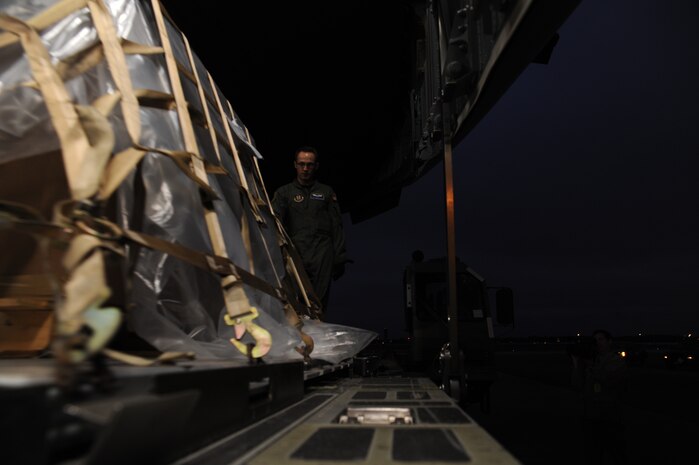 Staff Sgt. Chuck O'Guinn pushes an high-priority pallet of cargo onto a C-17 from Travis Air Force Base while parked on the Charleston Air Force Base flightline Jan. 22, 2010. The pallet included a large amount of money in support of the U.S. Embassy in Port-au-Prince, Haiti. Sergeant O'Guinn is a loadmaster from the 728th Airlift Squadron at McChord AFB, Wash. (U.S. Air Force photo/Senior Airman Katie Gieratz)(RELEASED)