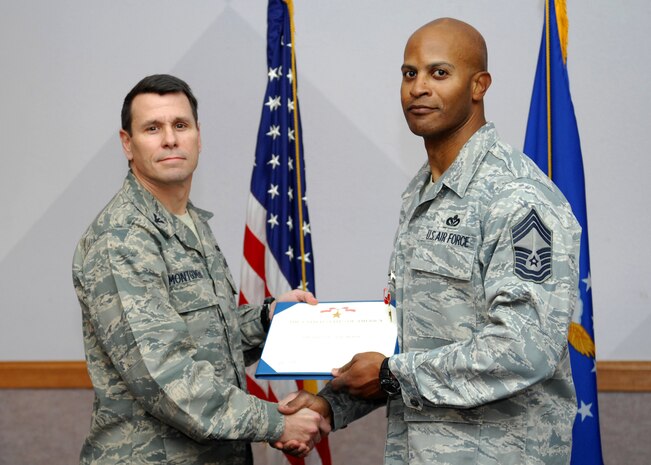 NELLIS AIR FORCE BASE, Nev.-- Col. John P. Montgomery, 98th Range Wing commander, presents Chief Master Sgt. Mark T. Darden, 98th Range Wing superintendent, with a Bronze Star Jan. 14 for his meritorious achievement while deployed to Joint Base Balad, Iraq and Al Udeid Air Base, Qatar.  Chief Darden served as the Chief Enlisted Manager for the 557th Expeditionary RED HORSE Squadron, 9th Air Expeditionary Task Force from Sept. 13, 2008 to April 1, 2009.  (U.S Air Force photo by Staff Sgt Taylor Worley)