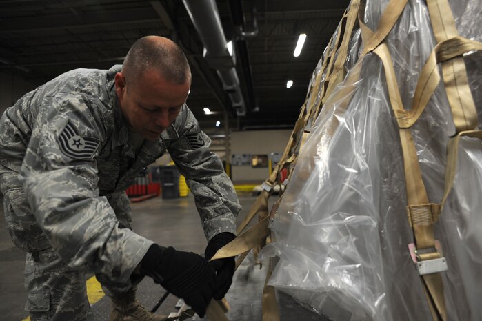 Tech. Sgt. Tim Crowe ties down pallet supporting more than 800 pounds in U.S. currency at Charleston AFB Jan. 22. The package contained a large amount of money to support the U.S. Embassy in Port-au-Prince Haiti. Sergeant Crowe is a special handling supervisor with the 437th Aerial Port Squadron. (U.S. Air Force photo/Senior Airman Katie Gieratz)(RELEASED)