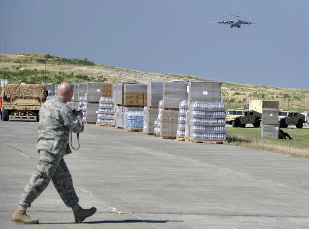 Master Sgt. Sean P. Houlihan prepares to take photos of a Charleston AFB C-17 Globemaster III arriving at Toussaint Louverture International Airport in Haiti's capital city of Port-au-Prince Jan. 18. Sergeant Houlihan is the 628th Air Base Wing public affairs superintendent and has made two trips to Haiti escorting media in support of Operation Unified Response. (U.S. Air Force
photo by Major Warren Neary)

