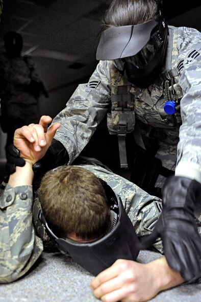 ELLSWORTH AIR FORCE BASE, S.D. -- Senior Airman Angela Gomez, 28th Security Forces Squadron team member, secures a role player during a training exercise, Jan. 25. Airmen received specific training from the Pennington County Sheriff’s Department special response team to neutralize a threat as quickly as possible. (U.S. Air Force photo/Airman 1st Class Matthew Flynn)