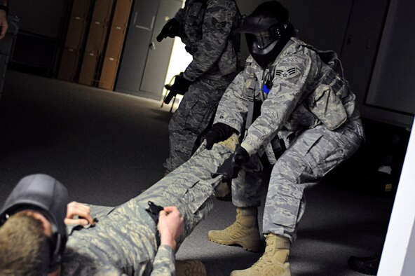 ELLSWORTH AIR FORCE BASE, S.D. -- Senior Airman Angela Gomez, 28th Security Forces Squadron team member, apprehends a role player during a training exercise, Jan. 25. Airmen were taught to secure all weapons after the threat had been neutralized during multiple training scenarios. (U.S. Air Force photo/Airman 1st Class Matthew Flynn)