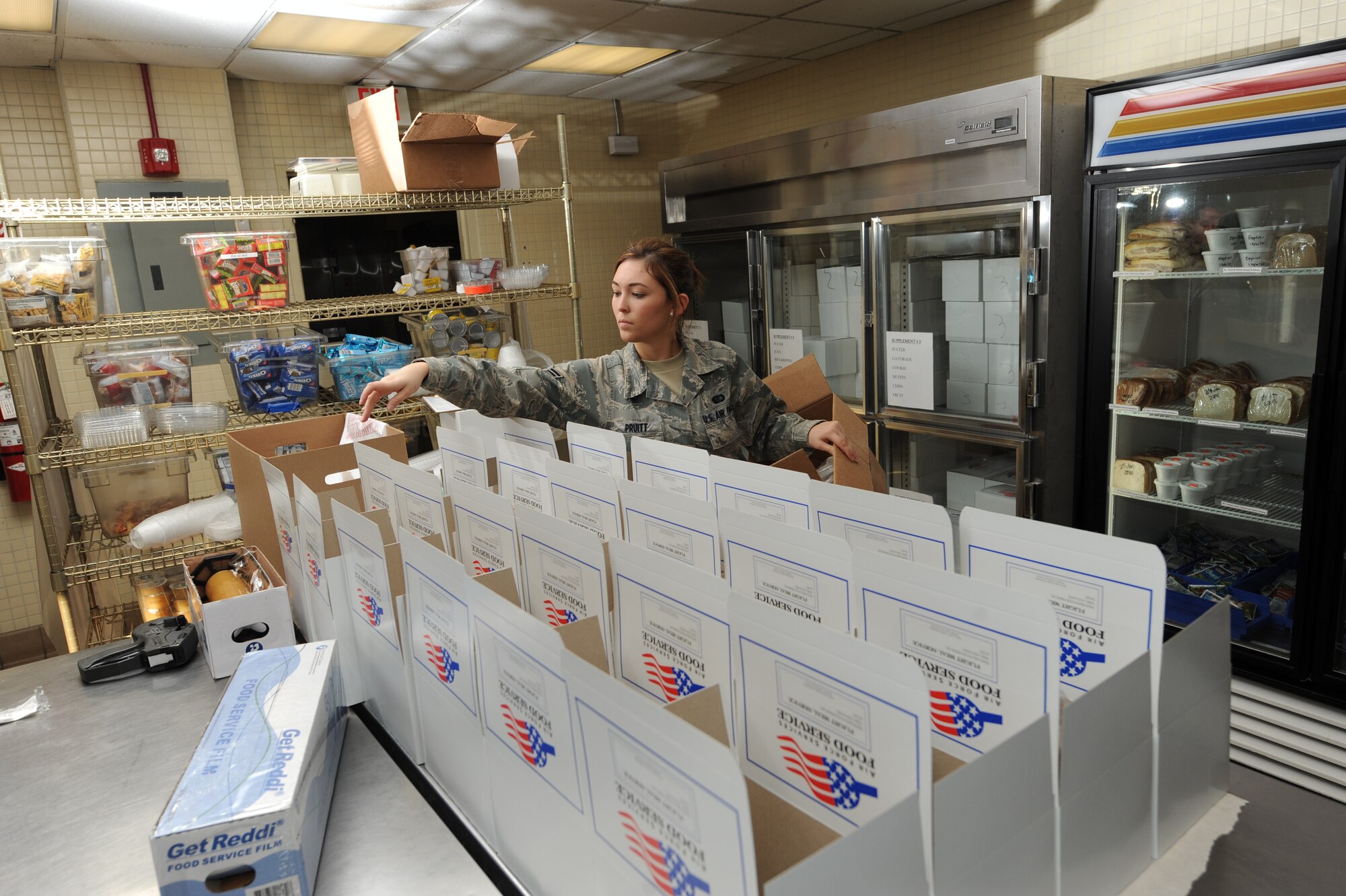 Airman 1st Class Alyssa Pruitt places food in containers for aircrews on Charleston AFB Jan. 16. Airman Pruitt is from the 628th Force Support Squadron and is a food services apprentice whose daily responsibilities include performing food deliveries and performing monthly inspections. Since the earthquake in Haiti Airman Pruitt's workload has increased due to more inbound and out bound aircraft. Airman Pruitt stated that she is grateful to have the opportunity to help the people of Haiti during their time of need. (U.S. Air Force photo/Senior Airman Katie Gieratz)(RELEASED)