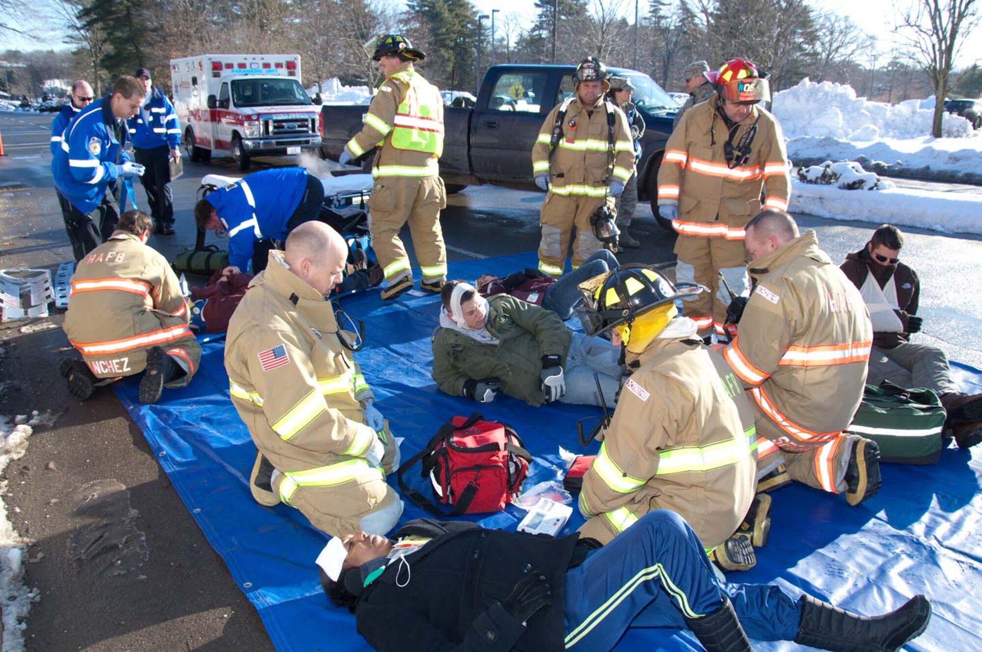 HANSCOM AIR FORCE BASE, Mass. – Hanscom firefighters along with Armstrong Ambulance team members attend to “the injured” during the mass casualty portion of the base readiness exercise conducted Jan. 19 to 21.   A temporary triage area was established in the middle of Vandenberg Drive to treat the victims of an explosion that was all part of the three day exercise event. (U.S. Air Force photo by Rick Berry)  
