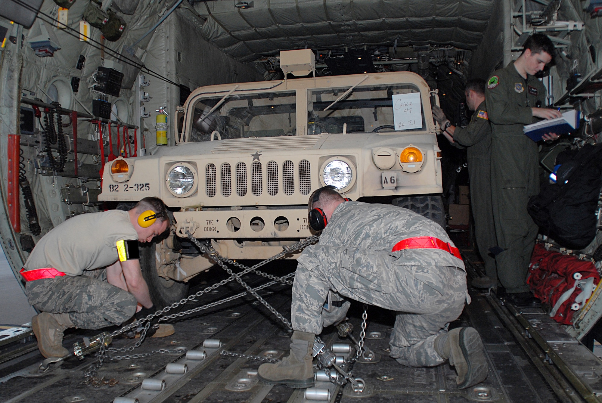 Crew chiefs from Little Rock Air Force Base secure an Army Humvee at Pope Air Force Base, N.C., onto a 41st Airlift Squadron C-130J bound for Haiti Jan. 19 in support of Operation Unified Response. The operation is a relief effort to help the victims of the recent earthquake in Haiti. (U.S. Air Force photo by Capt. Joe Knable)