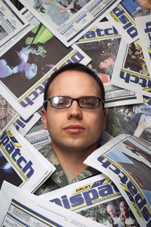 Staff Sgt. Daniel Bowles lies buried among Airlift Dispatch newspapers Jan. 27. Sergeant Bowles is one of many public affairs personnel who work to ensure the Air Force's role in supporting Haitian relief efforts is properly documented and reported. Sergeant Bowles is a journalist with the 628th Air Base Wing Public Affairs Office. (U.S. Air Force photo/Staff Sgt. Barry Loo)