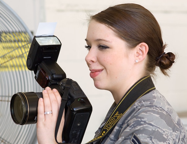 Airman 1st Class Lauren Main composes a scene Jan. 25 for an upcoming story on Charleston AFB's role in supporting Operation Unified Response. Airman Main is one of many public affairs personnel who work to ensure the Air Force's role in supporting Haitian relief efforts is properly documented and reported. Airman Main is a still photographer with the 628th Air Base Wing Public Affairs Office. (U.S. Air Force photo/Staff Sgt. Barry Loo)