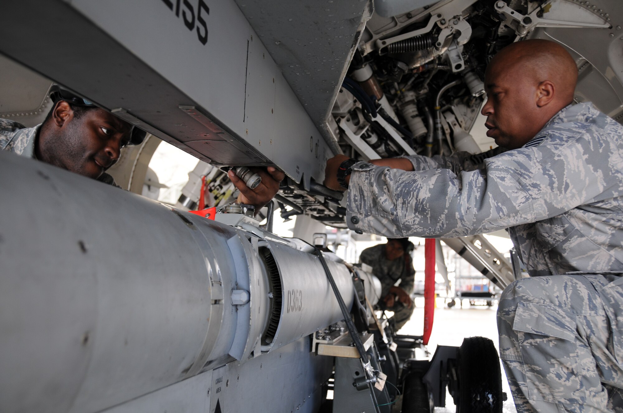 EGLIN AIR FORCE BASE, Fla. – (left to right) Staff Sgt. Tracy Lipscomb, Senior Airman Durral Mason and Tech. Sgt. Jerome Winston, 16th Electronic Warfare Squadron, prep the underside of an F-16 Fighting Falcon before attaching an electronic counter measures pod. The 16th EWS tests and delivers information that protects today’s warfighters from a multitude of threats. The squadron consists of four flights, a detachment and a cadre of individuals laying the foundation for the next generation of electronic warfare. (U.S. Air Force photo/ Airman 1st Class Anthony Jennings)