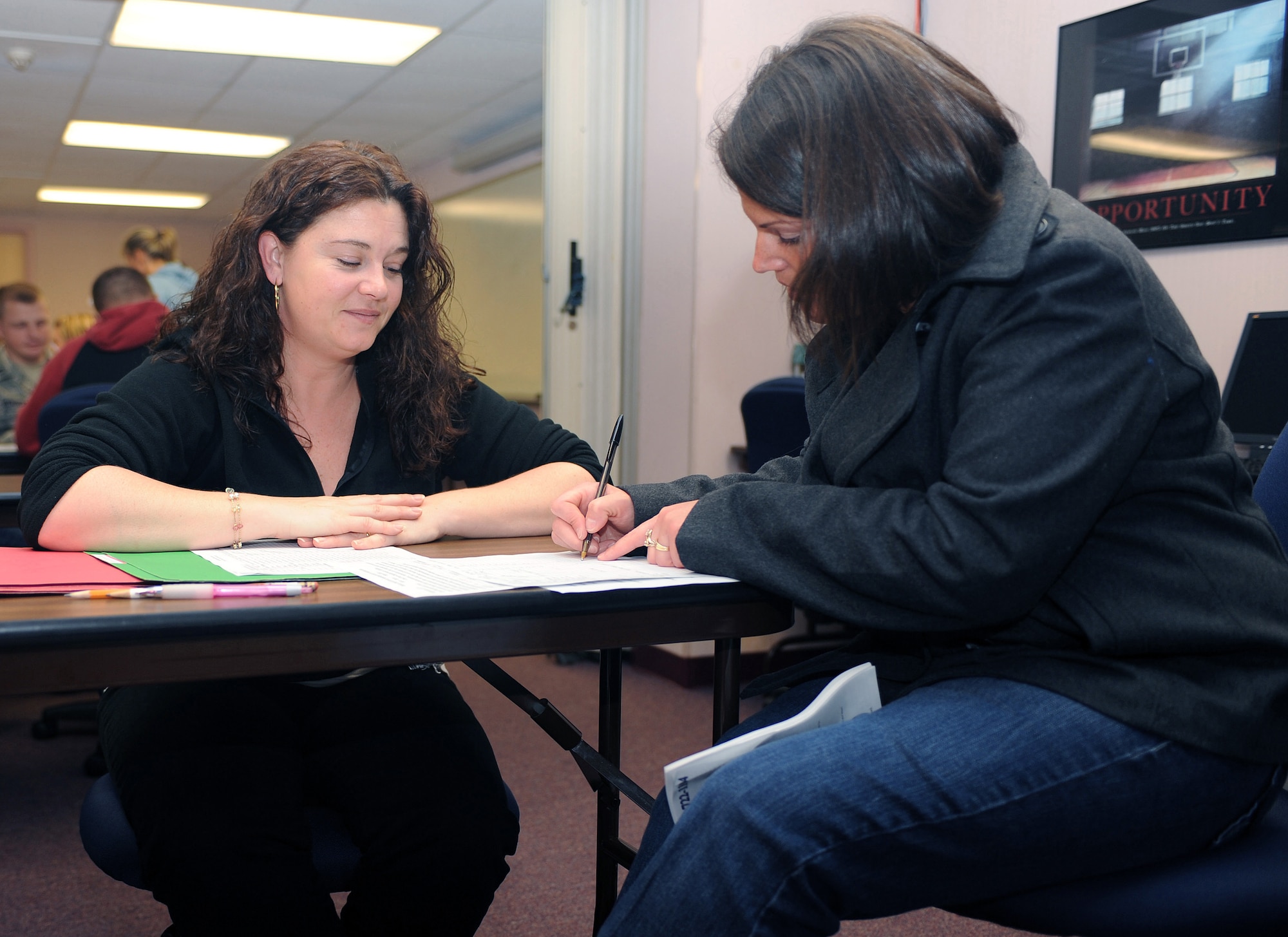 Sharon Grieve, outdoor recreation assistant manager, looks on as Maria Coates signs up for some of the trips and activities outdoor recreation scheduled as part of the Year of the Air Force Family DePLAYment program during an information fair on Seymour Johnson Air Force Base, N.C.,  Jan. 22, 2010.  Her husband, Staff Sgt. Steve Coates, 335th Fighter Squadron intelligence noncommissioned officer in charge, recently returned from a deployment. (U.S. Air Force photo/Tech. Sgt. Lesley Waters)