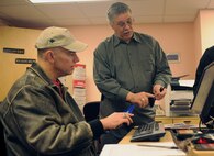 Charles Franklin, Airman & Family Readiness Center discovery resource center manager, explains how the DePLAYment tag pass works to Lt. Col. Christopher Anthony, 335th Fighter Squadron commander, during an information fair on Seymour Johnson Air Force Base, N.C.,  Jan. 22, 2010. The DePLAYment program is part of the Year of the Air Force Family initiative which concludes July 2010.  (U.S. Air Force photo/Tech. Sgt. Lesley Waters)