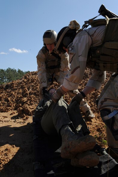MOODY AIR FORCE BASE, Ga. -- Staff Sgt. Eric Schanafelt and Senior Airman Noah Landwerlen, 38th Rescue Squadron pararescuemen, lift a simulated casualty onto a litter during a mass casualty exercise at Spence Air field in Moultrie, Ga., Jan. 25. Sergeant Schanafelt and Airman Landwerlen had to use precaution while lifting because of the possible spinal injuries the victim had received from the explosion. (U.S. Air Force photo by Airman 1st Class Benjamin Wiseman)