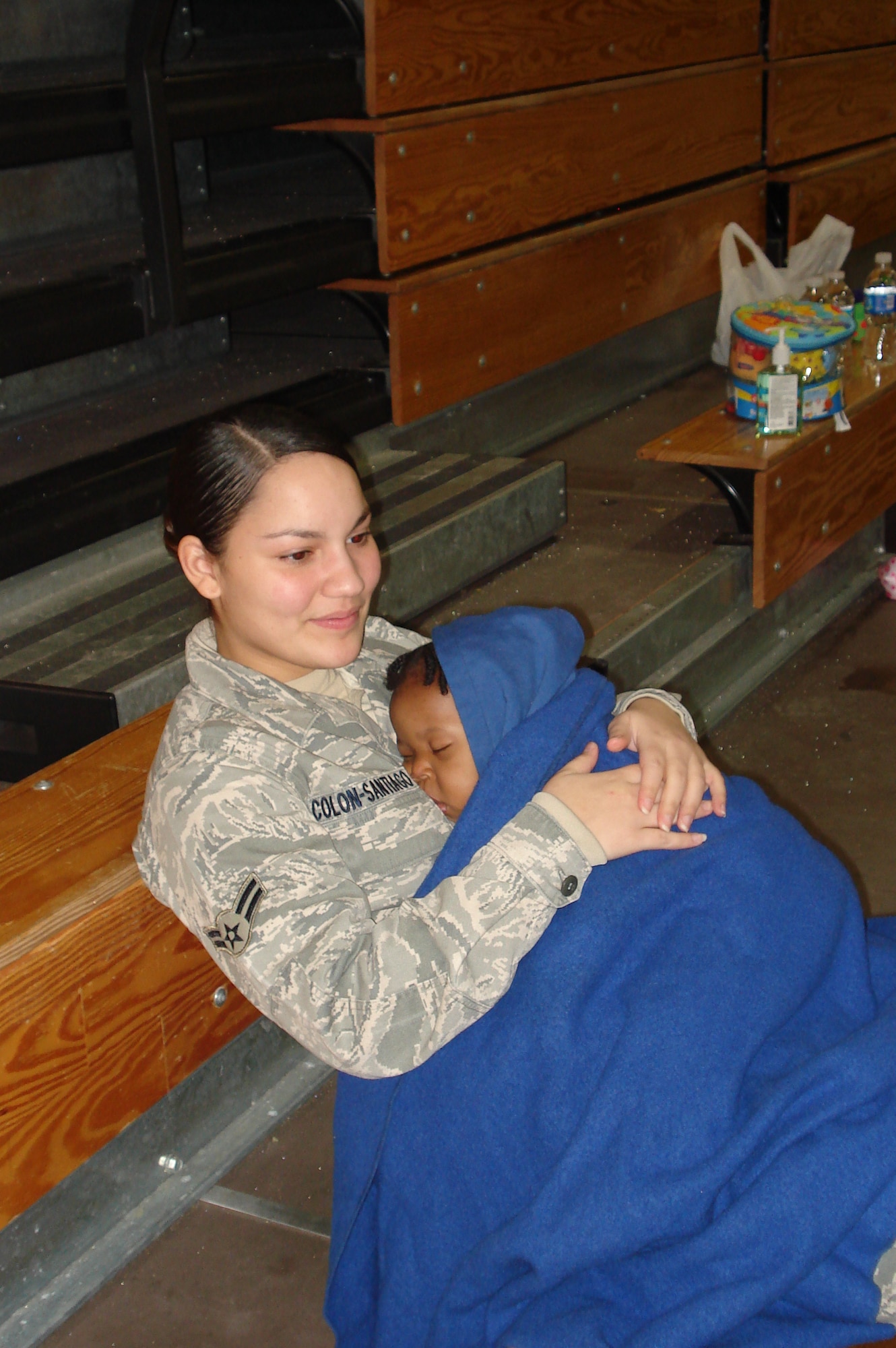 Airman 1st Class Mayra Colon-Santiago, holds 10-month-old Eving Feneus while the mother rests after a flight to McGuire from Haiti after the island nation was struck by a 7.0-magnitude earthquake. (U.S. Air Force Photo/Pascual Flores)