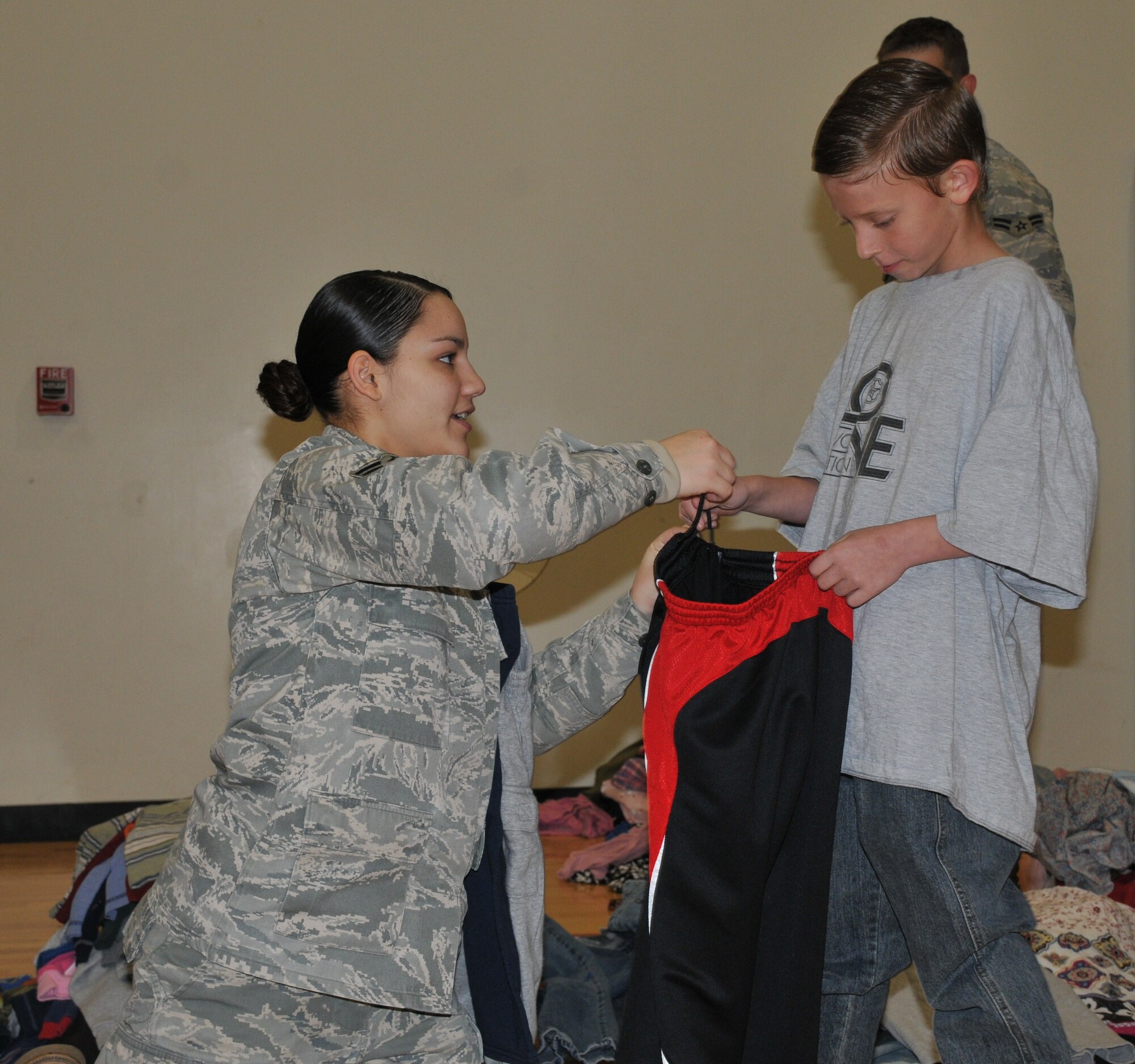 Airman 1st Class Mayra Colon-Santiago, 87th Logistics Readiness Squadron, provides an evacuee from the Haitian earthquake  with a pair of pants. Many evacuees arrived at McGuire with just the clothes they were wearing at time of evacuation, Jan. 15. (U.S. Air force photo/Pascual Flores)