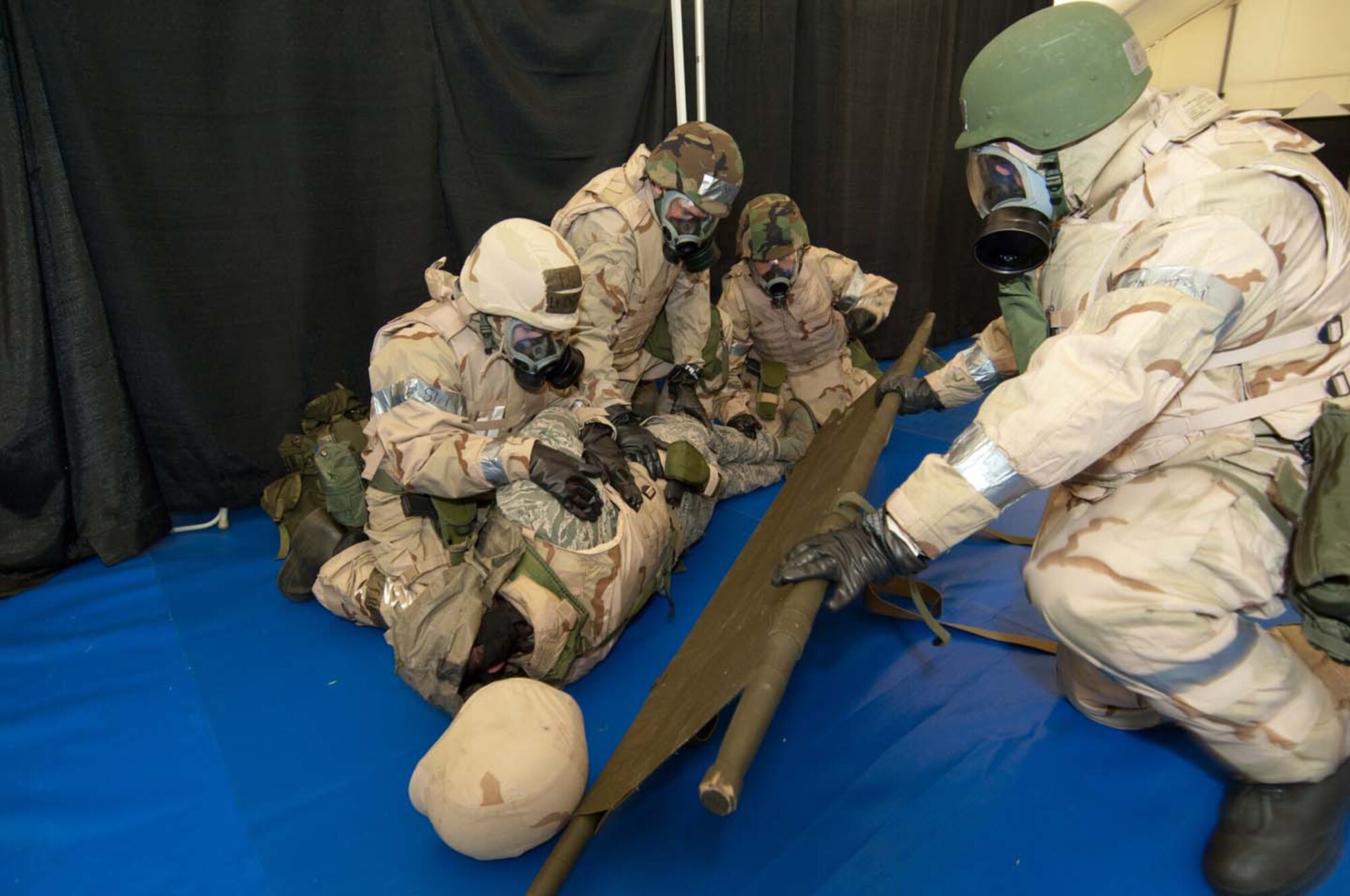 HANSCOM AIR FORCE BASE, Mass. – Hanscom team members take care as they prepare to place a “wounded” comrade on a stretcher for medical transport during the most recent Base Readiness Exercise.    The BRE tested Hanscom personnel over three days in various exercise scenarios.  (U.S. Air Force photo by Rick Berry)