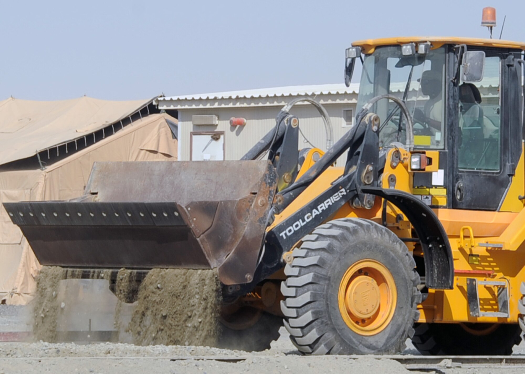 An Airman from the 380th Expeditionary Civil Engineer Squadron uses a front-end loader to move dirt for a project during operations at a non-disclosed base in Southwest Asia on Jan. 26, 2010. The 380th ECES cares for the infrastructure for the 380th Air Expeditionary Wing through work such as this.  The 380th AEW is comprised of four groups and 12 squadrons and the wing's deployed mission includes air refueling, surveillance and reconnaissance in support of overseas contingency operations in Southwest Asia.  The wing supports Operation Iraqi Freedom, Operation Enduring Freedom and the Combined Joint Task Force-Horn of Africa. (U.S. Air Force Photo/Tech. Sgt. Scott T. Sturkol/Released)