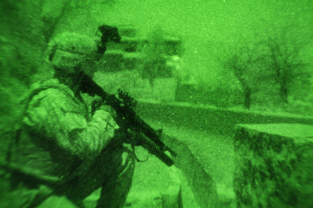 As seen through a night vision device, U.S. Army Sgt. David Ellis takes up a security position along the camp’s exterior during a night patrol of the perimeter, Camp Wright, Asadabad, Afghanistan, Jan. 24, 2010. Ellis is assigned to the Provincial Reconstruction Team-Kunar security forces member from the Nevada National Guard’s 1st Squadron, 221st Calvary Regiment.