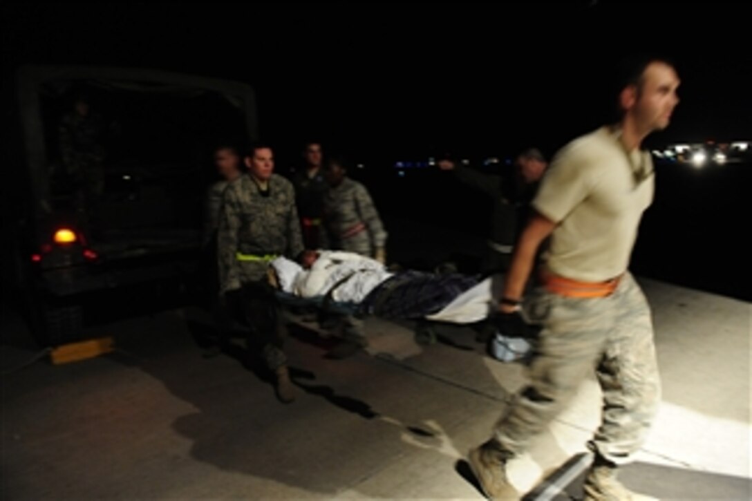 Medical personnel load earthquake victims into a U.S. Air Force C-130 Hercules aircraft at Toussaint L’Ouverture International Airport in Port-au-Prince, Haiti, on Jan. 25, 2010.  Department of Defense assets have been deployed to the island to assist with the Haitian relief effort.  