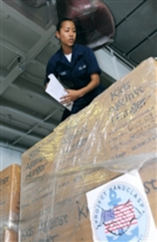 U.S. Navy Seaman Priscilla Vasquez, temporarily assigned to the religious ministry department of the aircraft carrier USS Carl Vinson (CVN 70), attaches French cooking instructions to pallets of food to be delivered to Haiti on Jan. 25, 2010.  The Carl Vinson and Carrier Air Wing 17 are conducting humanitarian and disaster relief operations as part of Operation Unified Response.  