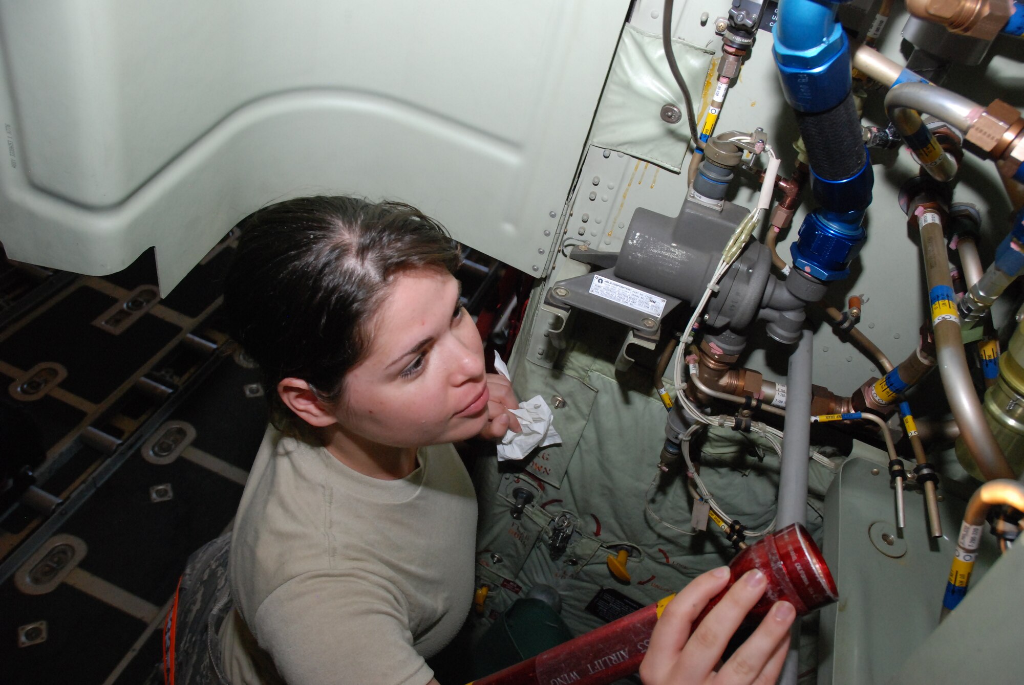 Senior Airman Rachael Fayas, 35th Expeditionary Airlift Wing crew chief, assigned from the Minnesota Air National Guard's 133rd Airlift Wing, inspects a C-130's utility hydraulic system prior to launching a C-130 in support of Operation Unified Response.  "I'm enjoying the opportunity to do what I originally signed-up for—to help people," said Airman Fayas.  (U.S. Air Force photo/Master Sgt. Stan Coleman)
