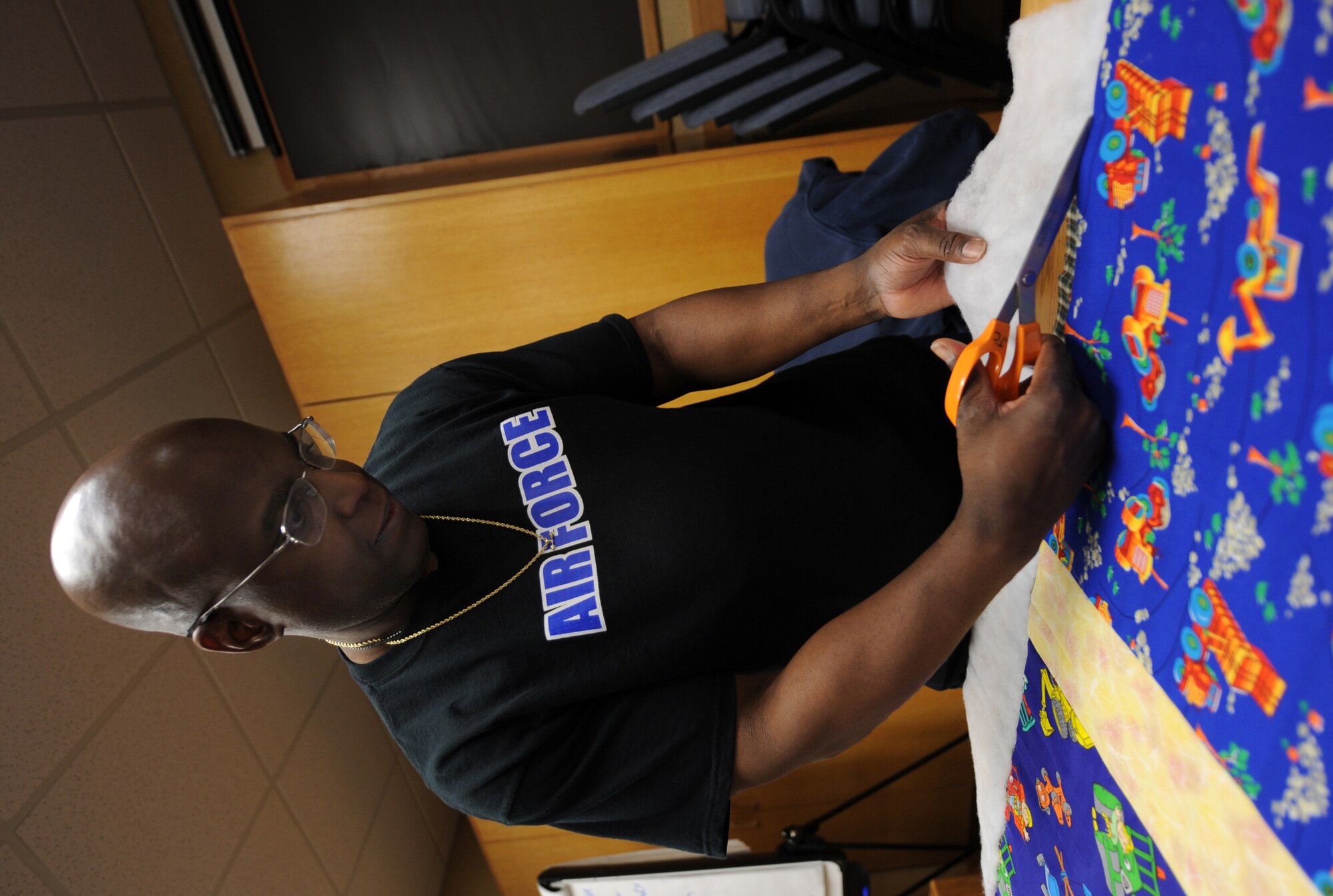 MOUNTAIN HOME AIR FORCE BASE, Idaho -- Capt. Harold McCants, 366th Medical Surgical Squadron operating room nurse, trims batting on a quilt during Hammond Quilt Day at the 366th Force Support Squadron Airman and Family Readiness Center Jan. 23. Volunteers assembled approximately 40 crocheted blankets, hats and cards into individual bundles to donate to families with newborn babies. (U.S. Air Force photo by Airman 1st Class Renishia Richardson)