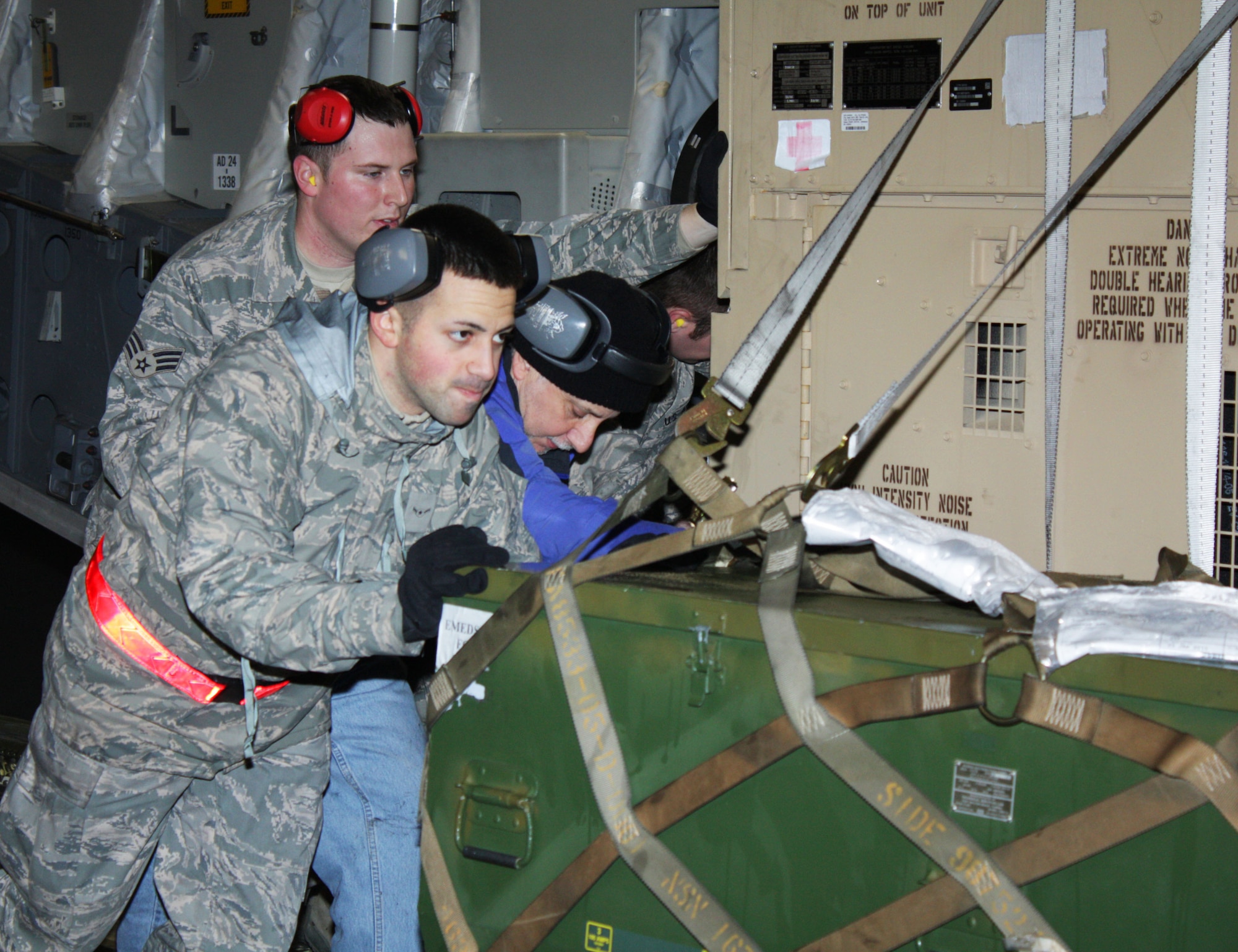 TRAVIS AIR FORCE BASE, Calif. -- The Travis Air Force Base flight line was a hub of activity into the wee hours of Sun., Jan. 24, as Team Travis Airmen prepared to leave for Haiti. Here, Airmen load equipment onto a C-17 Globemaster. About 20 members of the 615th Contingency Response Wing left late Saturday night in the C-17, loaded with equipment and supplies for Haitian relief. The 60th Air Mobility Wing, 615th CRW and 349th public affairs Airmen welcomed media from four television stations and a local newspaper, who interviewed Airmen and family, and filmed the departure, including footage from inside the aircraft just before the door closed. After a few hours rest, coffee and a snack, the PA Airmen met up with PA from David Grant Medical Center to escort media filming the departure of 38 medical personnel in the wee hours of the morning. In addition to medical supplies, medicines and equipment, the medical team packed a mobile hospital, fondly known as "hospital in a box," onto their awaiting C-17. Travis Airmen providing support for the Haitian relief efforts could be gone for anywhere from two weeks to six months, as needed. (U.S. Air Force photo/Staff Sgt. Meredith Mingledorff)