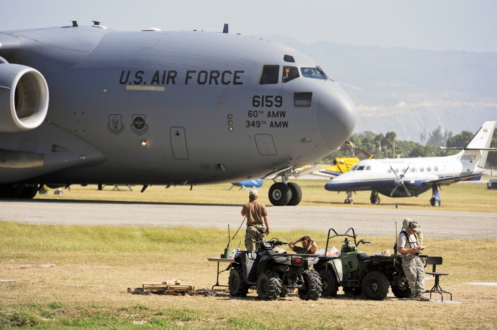 Combat controllers guide a cargo aircraft from Travis Air Force Base, Calif., into Toussaint L'Ouverture International Airport Jan. 23, 2010, in Port-au-Prince, Haiti. The Airmen are from the 23rd Special Tactics Squadron at Hurlburt Field, Fla. (U.S. Air Force photo/Staff Sgt. Desiree N. Palacios)