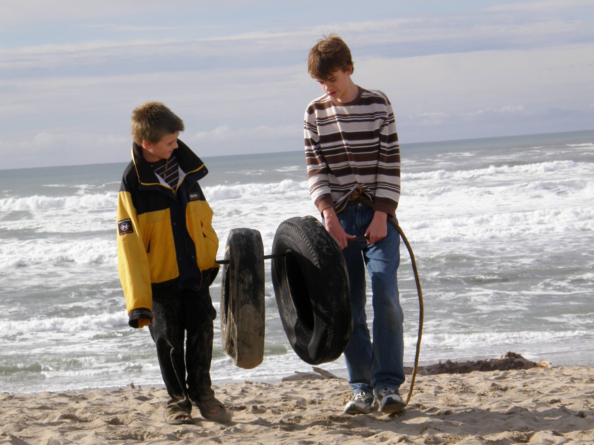 VANDENBERG AIR FORCE BASE, Calif. – Muscling two tires from the Pacific Ocean, Ki Terrill and Gavin Terrill, of the Vandenberg Home-school Inclusive Partnership, help clean-up Wall Beach here Monday, Jan. 28, 2010. The team of Vandenberg home-schoolers removed trash and nine tires from the beach. (Courtesy photo/Vandenberg Home-school Inclusive Partnership)