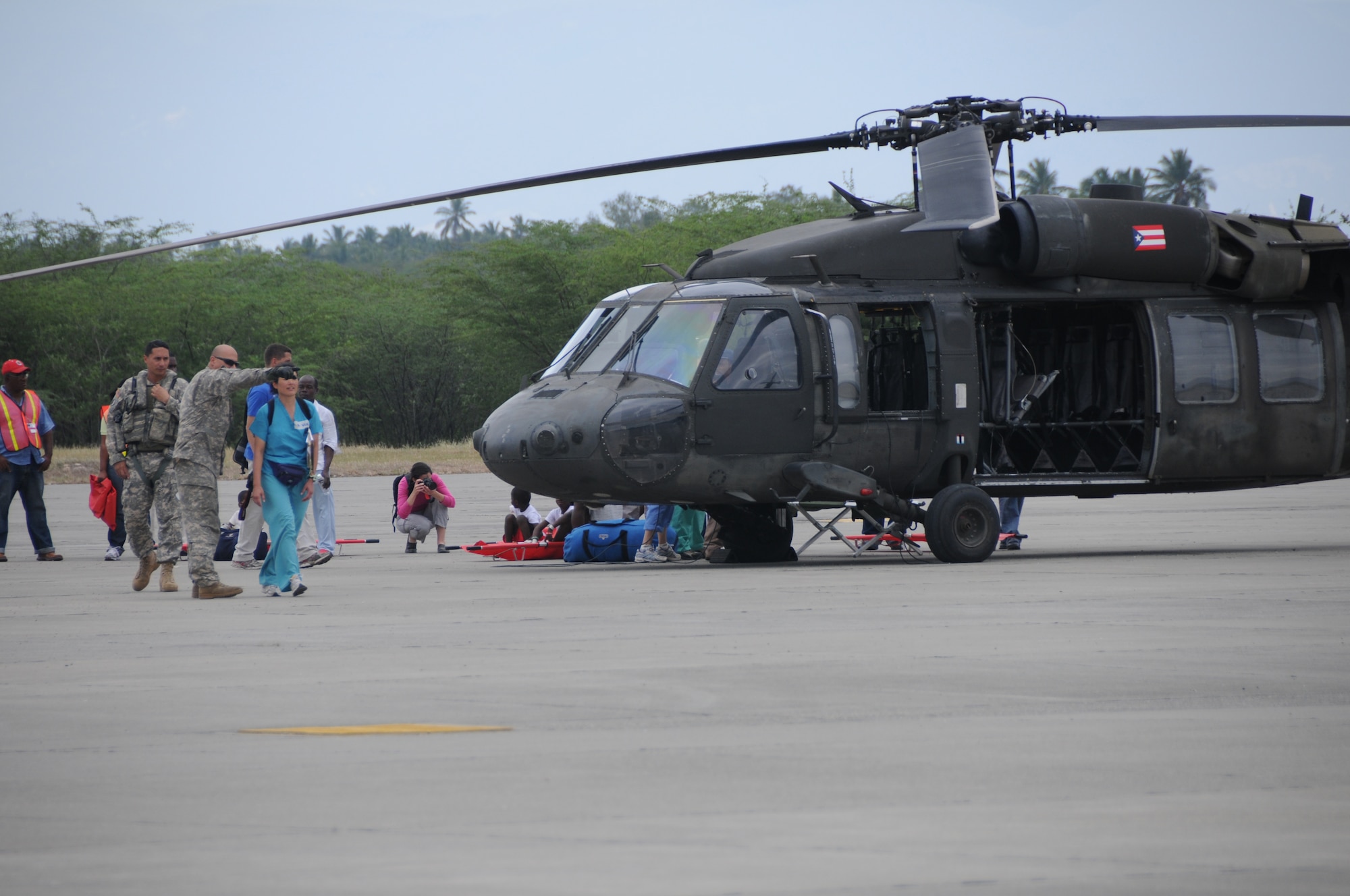 Airmen from the Kentucky National Guard's 123rd Contingency Response Group help offload wounded Haitian refugees and medical personnel from Puerto Rico National Guard UH-60 Blackhawk helicopters at the air hub in Barahona, Dominican Republic, Jan. 25, 2010. (U.S. Air Force photo by Tech.
Sgt. Dennis Flora, Kentucky National Guard)