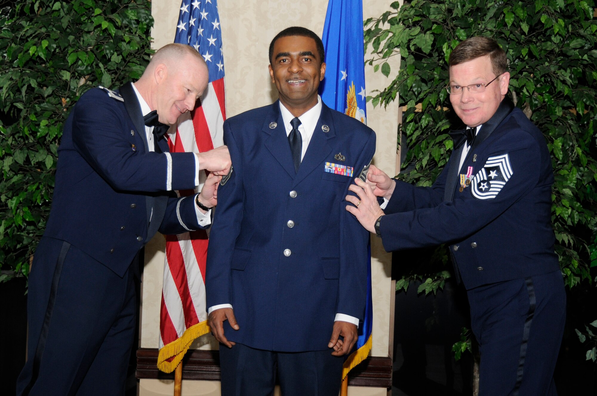 SCOTT AIR FORCE BASE, Ill. -- Master Sgt. John Simien, 375th Communications Group, is tacked on by Col. Gary Goldstone, 375th Air Mobility Wing commander, and Chief Master Sgt. James Suttles, 375th AMW command chief, after being promoted under the Stripes for Exceptional Performers Program Jan. 21 during the Wing Annual Awards Dinner at the Scott Club. Sergeant Simien mastered 26 hours of advanced voice switching training earning Department of Defense mandated security, plus commercial certification. As the Voice Systems NCOIC, he led 20 technicians overseeing 13.5 million calls per month and achieving a 99 percent successful connection rate. He led and coordinated five maintenance teams to resolve 1,477 work-orders and 650 trouble calls guaranteeing communication to the Scott populace. He also completed 18 credit hours toward his Bachelors Degree in Information Technology leaving just one class left for his degree. (U.S. Air Force photo/Staff Sgt. Brian Ellis)

