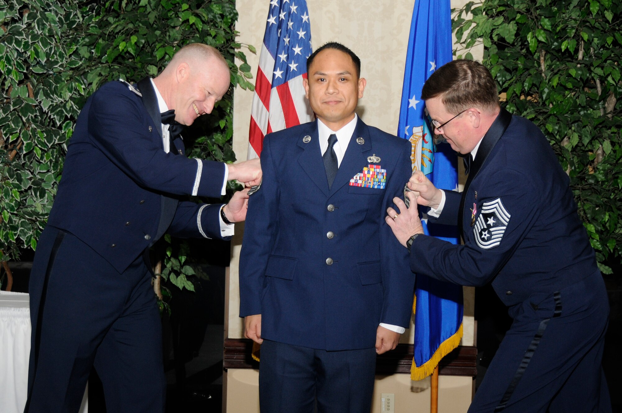 SCOTT AIR FORCE BASE, Ill. -- Tech. Sgt. Michael Krause, 375th Communications Group, is tacked on by Col. Gary Goldstone, 375th AMW commander, and Chief Master Sgt. James Suttles, 375th AMW command chief, after being promoted under the Stripes for Exceptional Performers Program Jan. 21 during the Wing Annual Awards Dinner at the Scott Club.  Sergeant Krause led a deployed command center move of 5,000 feet of cable, 75 systems and 25 phones. He excelled under fire while on a mission with the Marine Corps providing communication. He expedited intelligence reports enabling rapid ammunition refills during firefight and helped confiscate 35 weapons, and thus earned a Bronze Star. He upgraded tactical systems on 42 vehicles enabling capability to locate partner combat teams across the area of responsibility. Sergeant Krause also designed an information technology test-bed, identified 20 critical program faults and corrected software interoperability shortfalls for 450 Air Operations Center command and control systems. (U.S. Air Force photo/Staff Sgt. Brian Ellis)

