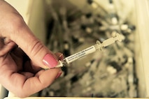 Debbie Law holds an H1N1 flu mist nasal container during a point of distribution exercise Jan. 21, 2010, at Offutt Air Force Base, Neb. Ms. Law is assigned to the 55th Medical Operations Squadron. (U.S. Air Force photo/Charles Haymond)