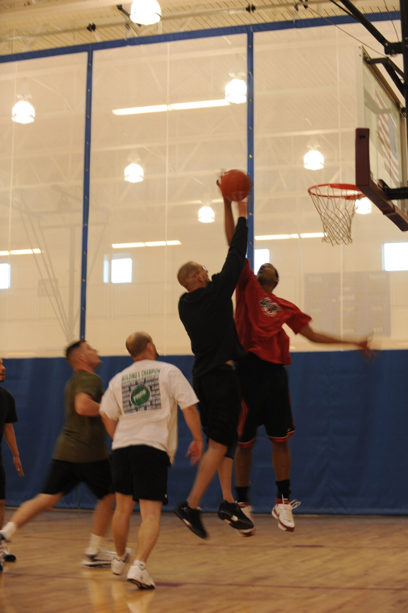BUCKLEY AIR FORCE BASE, Colo. -- Staff Sgt. Alfred Davis, 4th Manpower Requirements Squadron, blocks Marine Corps Staff Sgt. Joseph Barotti, Marine Air Control Squadron 23, as he goes up for a shot during the 3 on 3 Hoops Classic at the base Fitness Center Jan. 27. (U.S. Air Force by Airman 1st Class Marcy Glass)